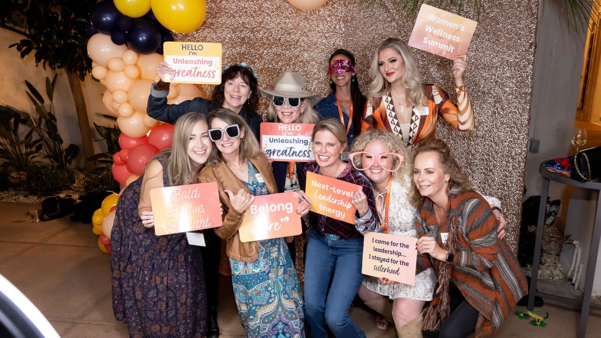 women pose in a photo booth carrying supportive signs